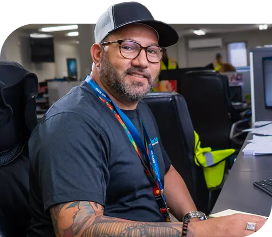 A Trailer Bridge employee sits at a desk in front of a computer.