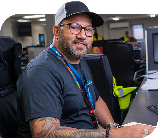 A Trailer Bridge employee sits at a desk in front of a computer.