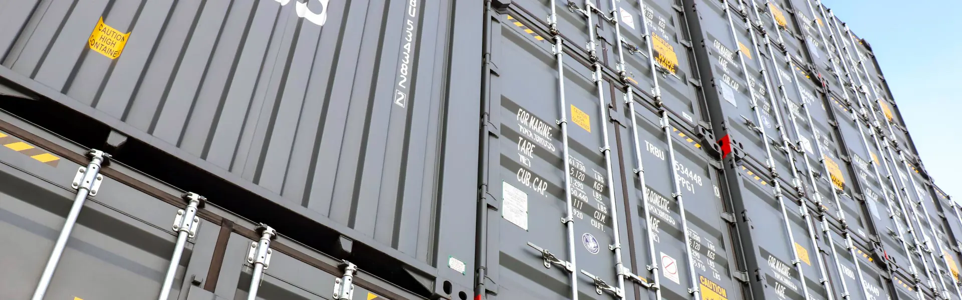 An angled shot looking up at a stack of shipping containers.