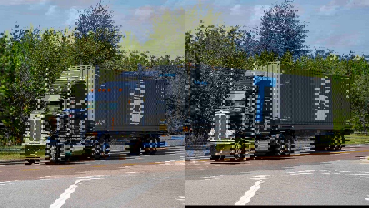 A Trailer Bridge truck drives down the road.