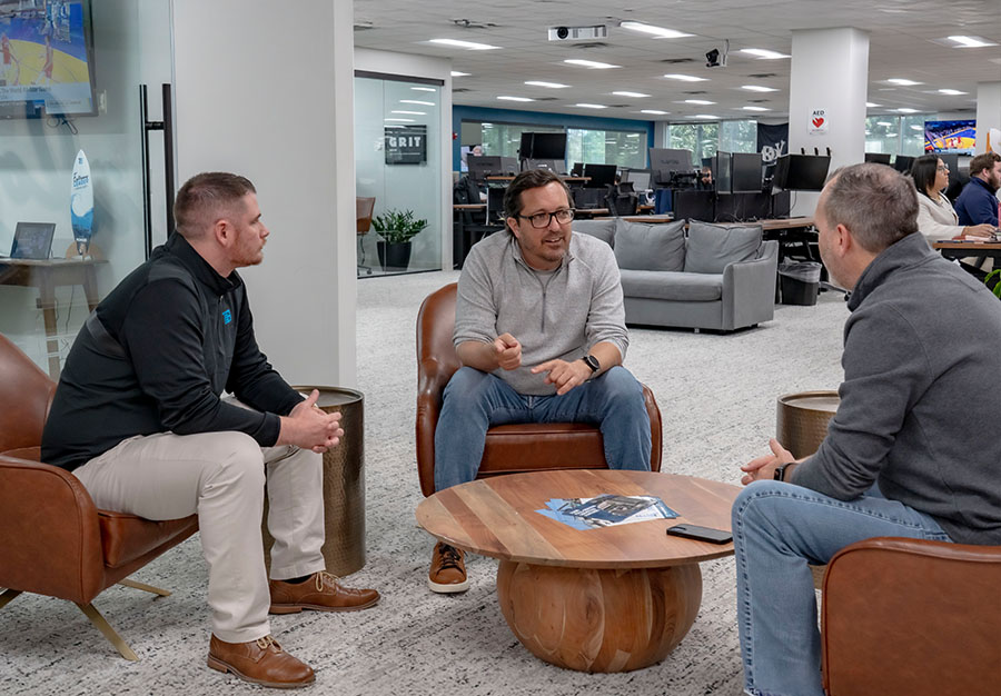 Trailer Bridge employees sitting and talking in the office. 
