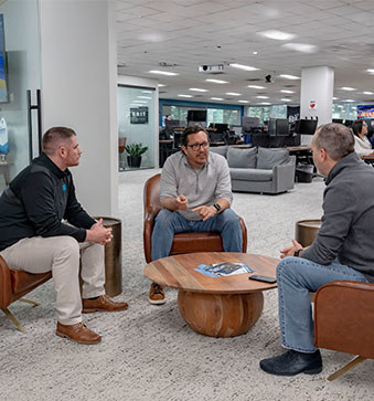 Trailer Bridge employees sitting and talking in the office. 