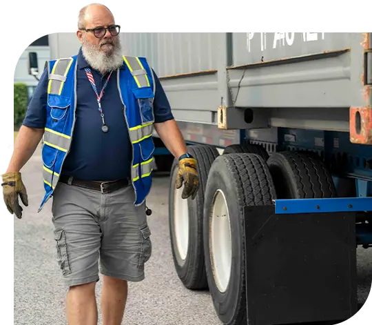 An employee walks around a parked truck.
