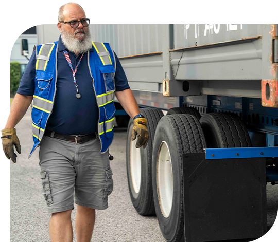 An employee walks around a parked truck.