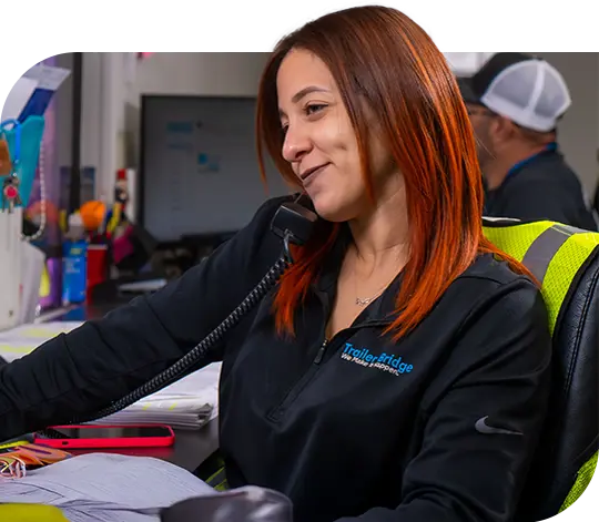 A friendly Trailer Bridge employee talks on a phone.