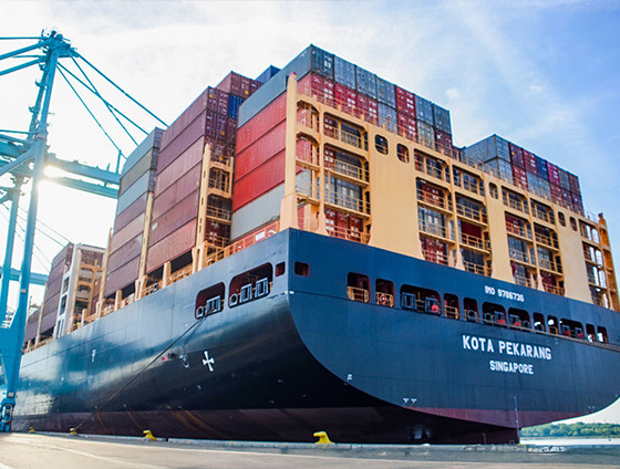 Stacks of shipping containers on a barge marked for Singapore.