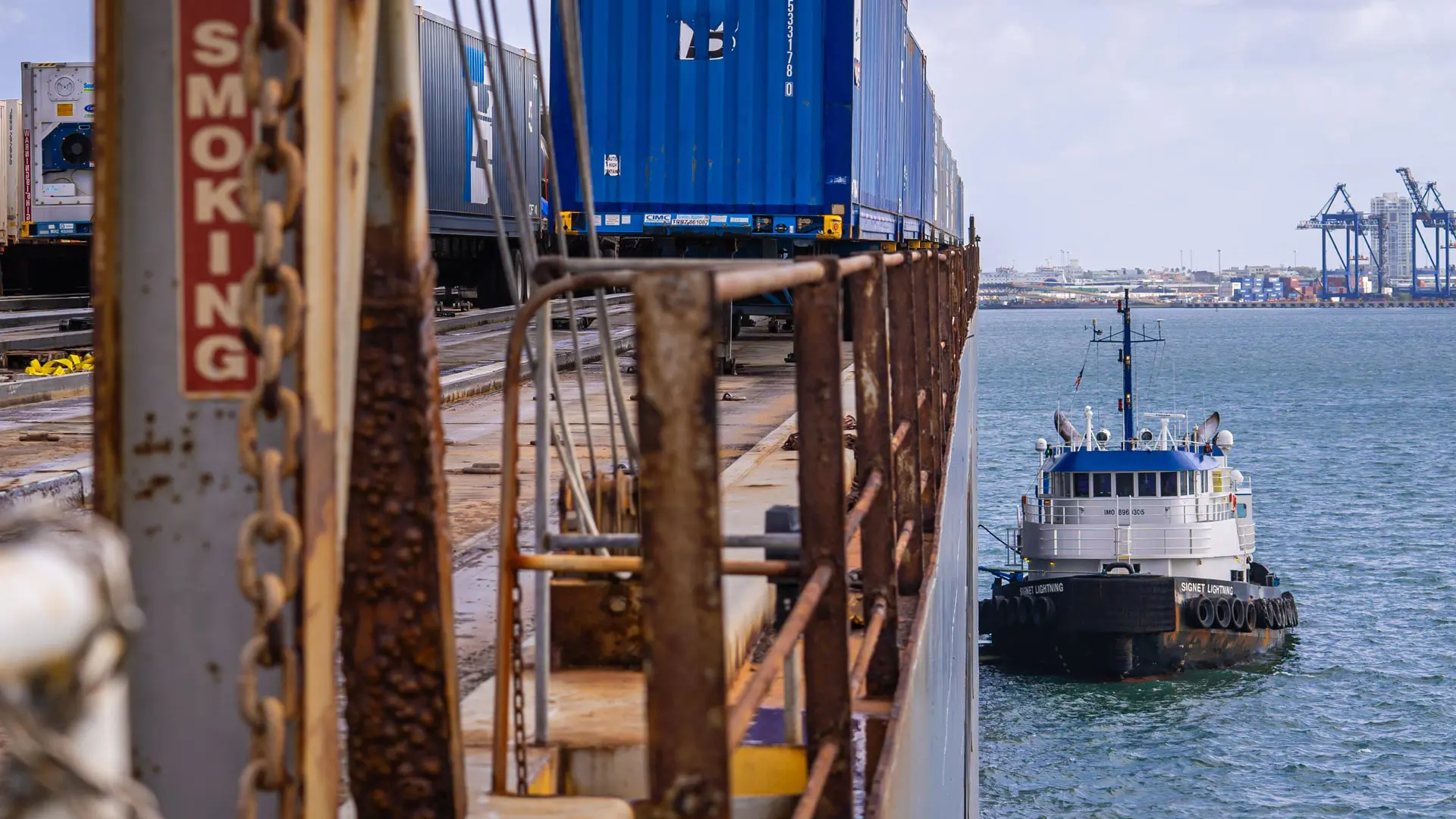 Tug boat pulled up next to a Trailer Bridge RORO barge.