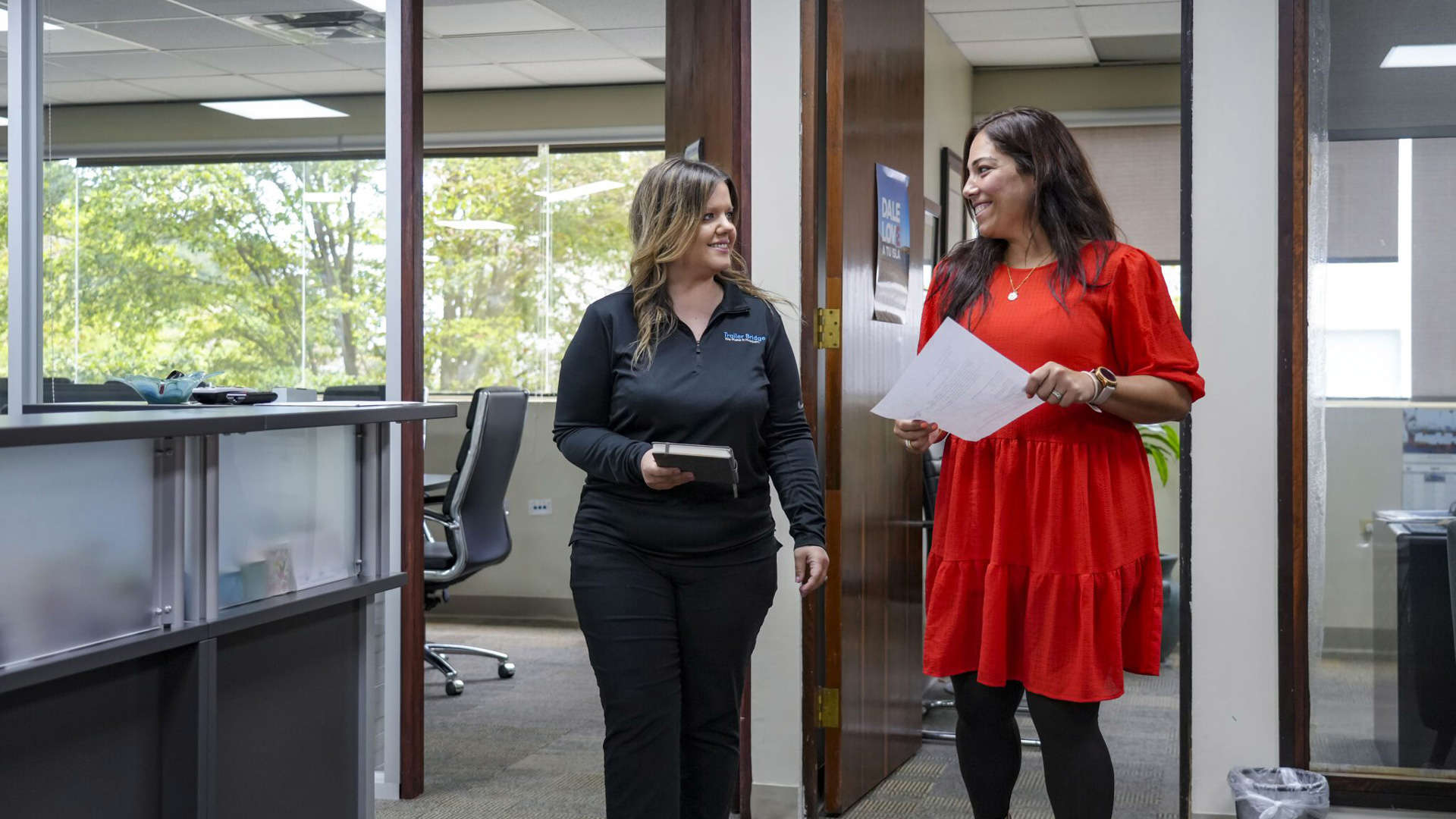 Two Trailer Bridge employees talk in the office.
