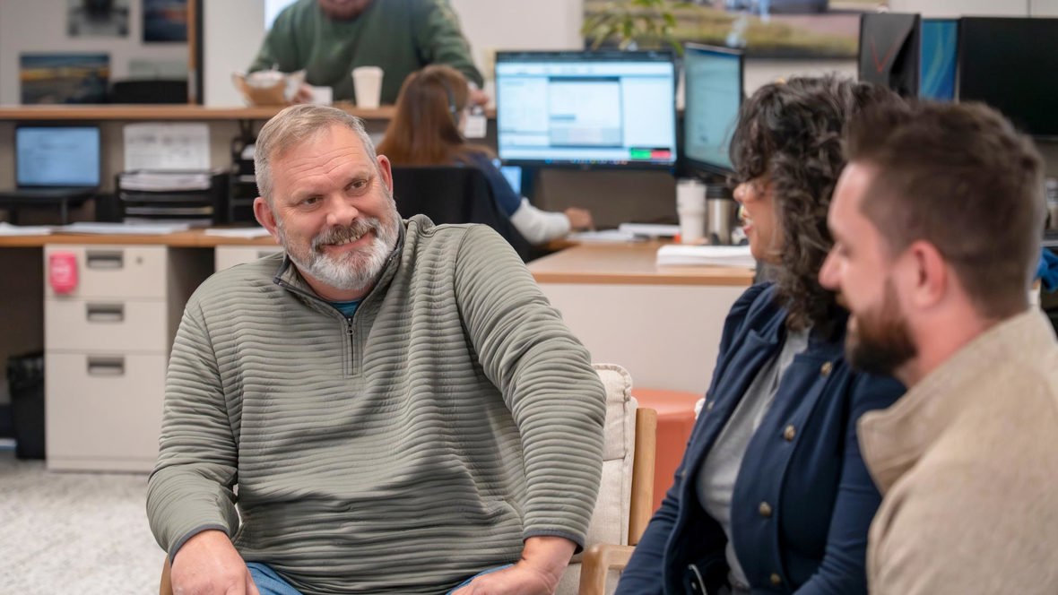 Trailer Bridge employees sitting down and talking.