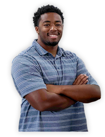 A Trailer Bridge employee with arms crossed smiles at the camera.