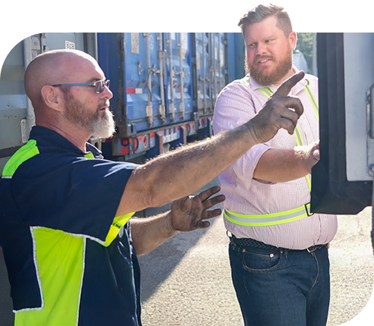 Two workers evaluate refrigerated truck equipment.