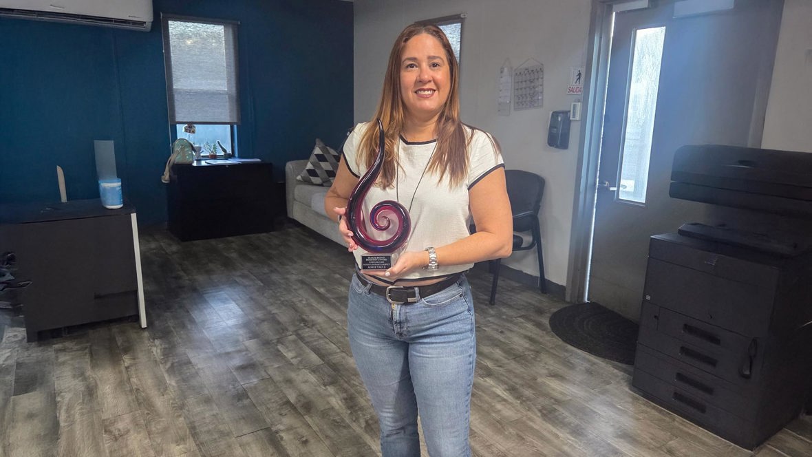 Aimee Taule accepting award from Mitch Luciano