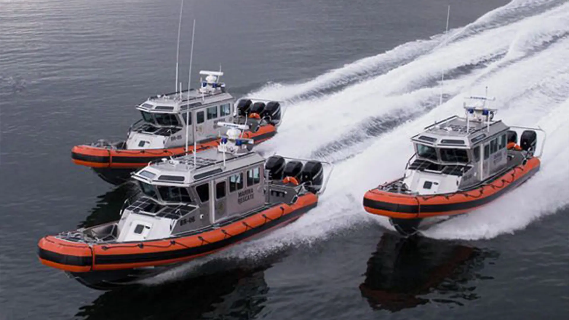 Three boats on the water moving fast.
