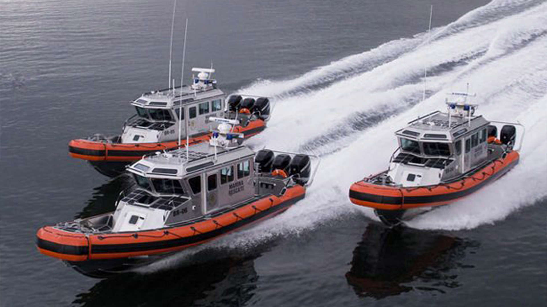 Three boats on the water moving fast.