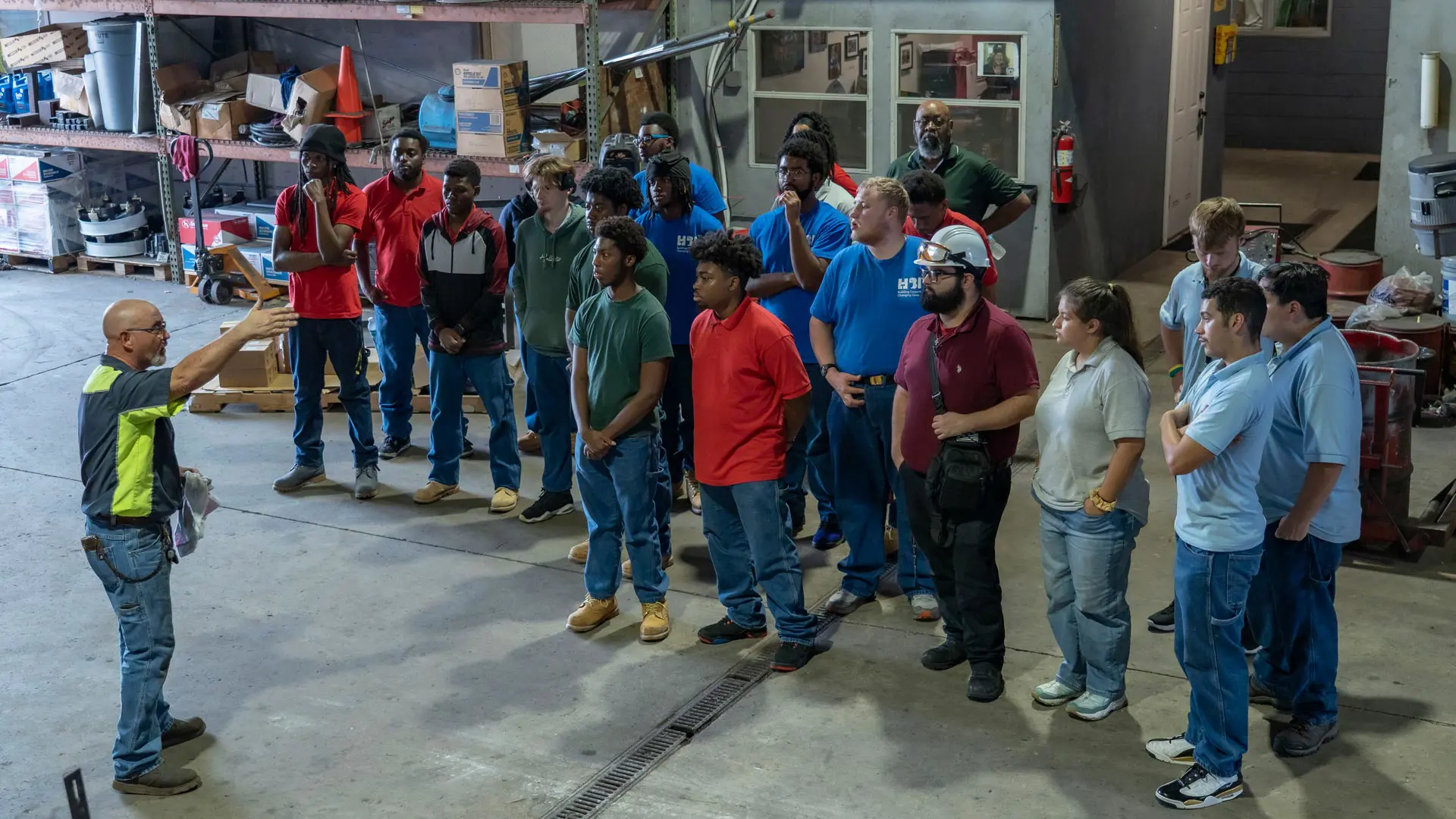Trailer Bridge maintenance worker speaking to a group from Job Corps.