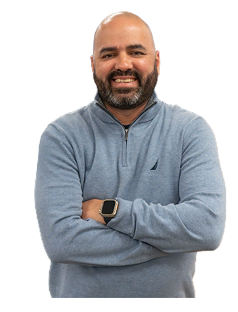 A Trailer Bridge employee smiles at the camera while standing.