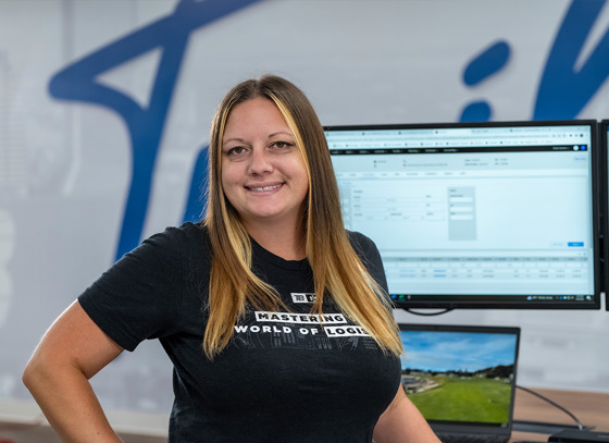 Trailer Bridge employee posed at desk smiling at camera